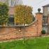 Hornbeam trees trained in a formal shape set against a brick wall in a customers garden